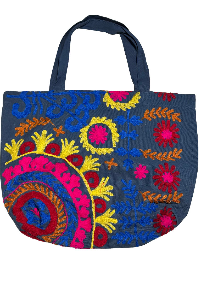 Sac de plage Suzani en toile avec des broderies en bleu marine, rose, jaune et vert, vue de face