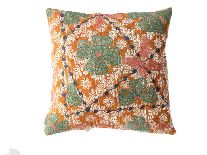 Suzani pudebetrÃ¦k i boho vintage stil med orange bund og hvide blomsterornamenter samt store grÃ¸nne blade med pink prikker og mÃ¸rkeblÃ¥ slyngende ranker.