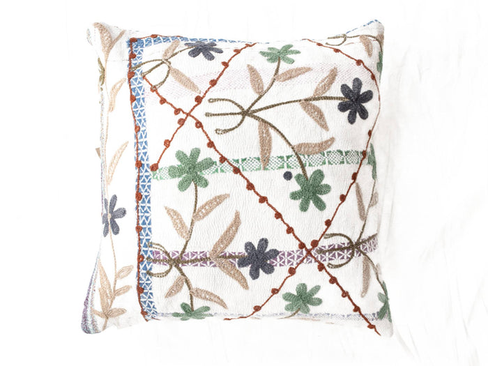 Suzani pillowcase 50x50 cm in white with colorful embroidered flowers in green, blue and gray as well as orange outlines and fringes for boho vintage