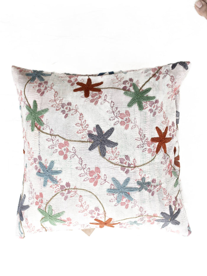 Einzigartiger Suzani-Kissenbezug (50 x 50 cm) aus cremeweißem Stoff mit bohemischer Ethno-Stickerei: geschwungene Ranken und bunte Blütensterne in Blau, Grün und Orange auf rosa Vintage-Muster